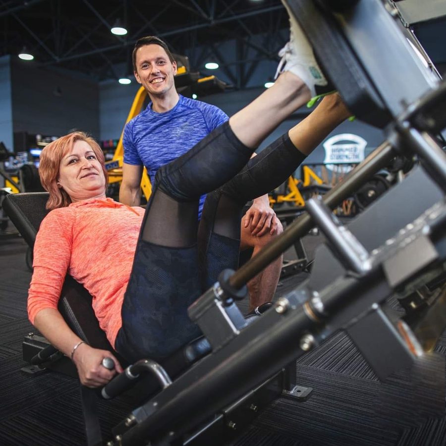 Ondřej Novák vede klientku při tréninku na leg pressu